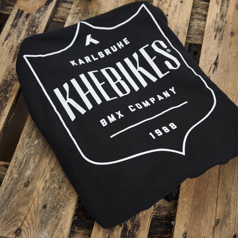 Zusammengelegter Hoodie mit weißem KHE Shield Logo 